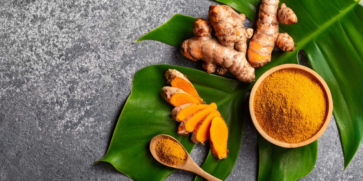 Turmeric,Powder,And,Fresh,Turmeric,Root,On,Grey,Concrete,Background